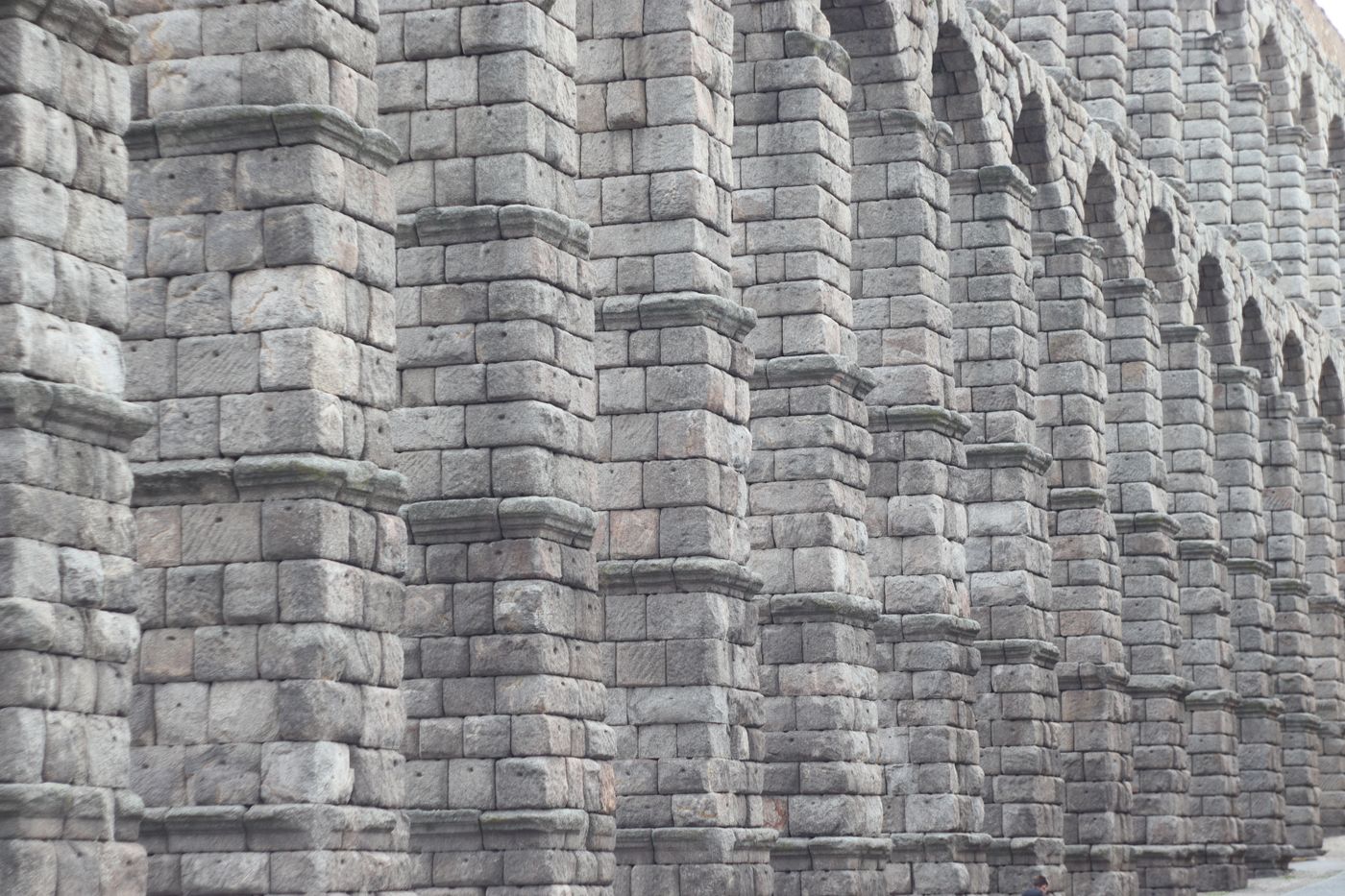 Detailed view of the Roman aqueduct's stone arches in Segovia, Spain.